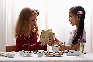 AsiaPix - two girls sharing a gift