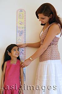 Asia Images Group - mother measuring daughter's height