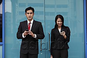 AsiaPix - Man and woman wearing suits holding phones
