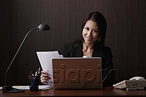 AsiaPix - Chinese woman sitting at desk smiling