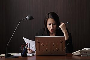 AsiaPix - Chinese woman looking at computer on shock