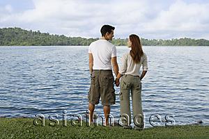 Asia Images Group - Couple standing by lake's edge