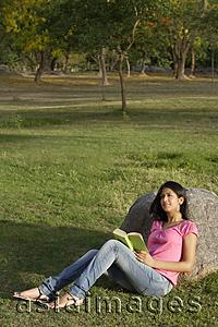 Asia Images Group - teen girl reading book in park