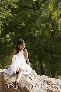 Asia Images Group - girl in white sari, sitting on rock