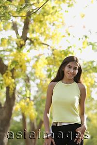 Asia Images Group - teen girl standing under blooming tree
