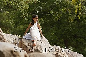 Asia Images Group - girl in white sari, sitting on rock