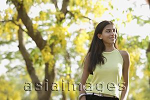 Asia Images Group - teen girl standing under blooming tree