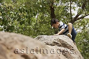 Asia Images Group - boy climbing on rocks