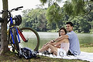 Asia Images Group - Couple resting by a lake