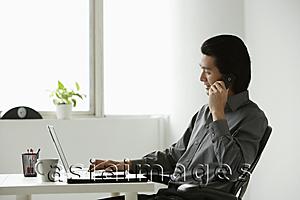 Asia Images Group - Young businessman at computer