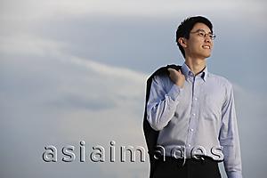 Asia Images Group - Businessman standing with jacket over shoulder