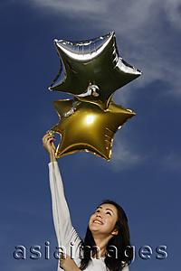 Asia Images Group - Young woman with star-shaped balloons