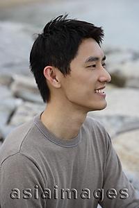 Asia Images Group - Profile of man sitting on seashore