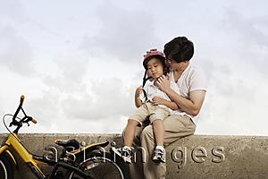 Asia Images Group - Father hugging son after bike ride