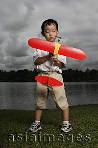 Asia Images Group - Young boy holding toy airplane