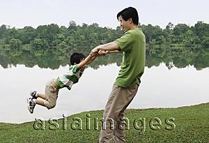 Asia Images Group - Father swinging son by arms