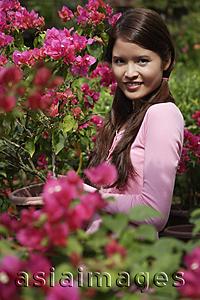 Asia Images Group - Young woman standing among flowers