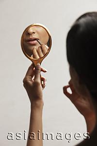 Asia Images Group - hand of woman holding up mirror with reflection