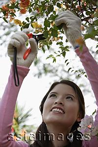 Asia Images Group - Young woman working in a garden