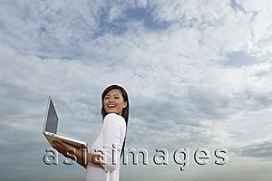 Asia Images Group - Young woman holding open laptop