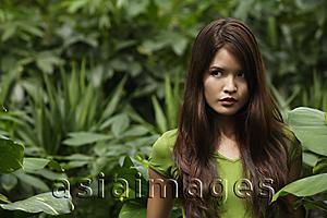 Asia Images Group - Young woman standing among plants