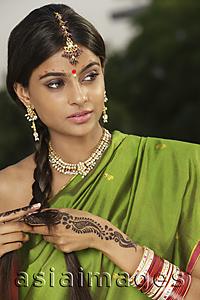 Asia Images Group - woman wearing sari and decorated with henna tattoo, traditional jewelry and bindi
