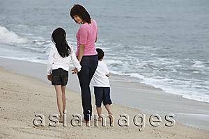 Asia Images Group - Young woman walking on beach with boy and girl