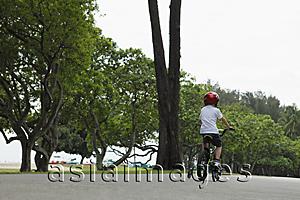 Asia Images Group - Young boy riding bike with training wheels