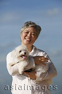 Asia Images Group - Older woman holding dog.