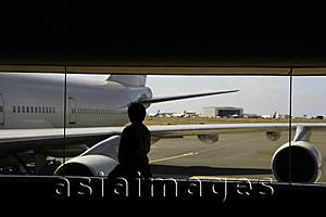 Asia Images Group - Young boy looking at airplane