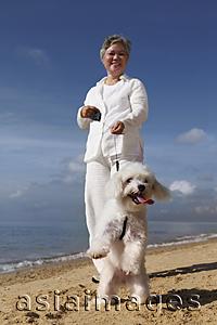 Asia Images Group - Older woman walking dog.