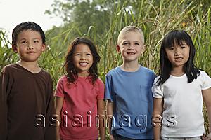 Asia Images Group - Four children standing together, smiling.