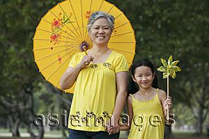 Asia Images Group - Older woman with young girl holding a pinwheel.