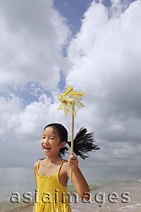 Asia Images Group - Young girl running with pinwheel.