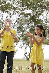 Asia Images Group - Older woman and young girl playing with bubbles.