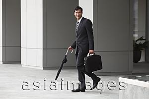 Asia Images Group - business man in suit carrying briefcase and umbrella