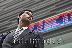 Asia Images Group - businessman standing before stock exchange