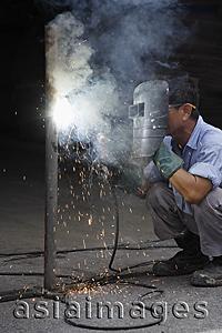 Asia Images Group - Mature man welding.