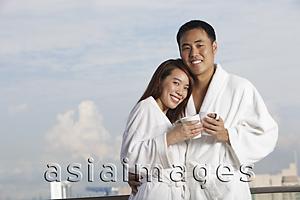 Asia Images Group - Young couple in robes hugging and smiling