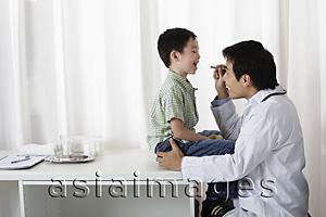 Asia Images Group - Doctor looking at young boy's mouth