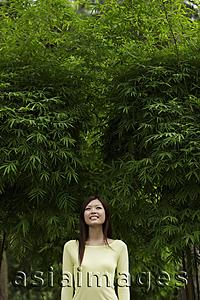 Asia Images Group - Young woman smiling in front of bamboo trees