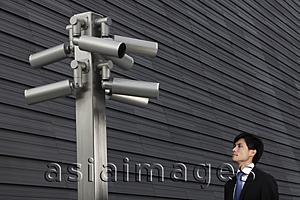 Asia Images Group - Man looking at surveillance cameras