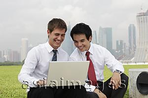 Asia Images Group - Chinese and Caucasian man looking at laptop out side