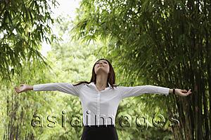 Asia Images Group - Young woman enjoying nature surrounded by bamboo trees