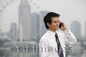 Asia Images Group - Chinese man talking on phone in front of city sky line