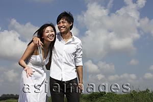 Asia Images Group - young couple laughing outside with arms around each other