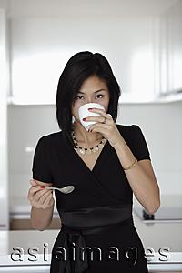 Asia Images Group - young woman drinking out of coffee mug