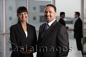 Asia Images Group - Indian man and woman in business attire smiling at camera.