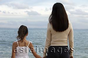 Asia Images Group - Rear view of mother and daughter holding hands looking at the water