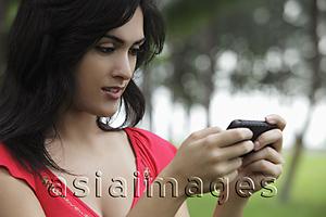Asia Images Group - Young woman looking at phone outdoors